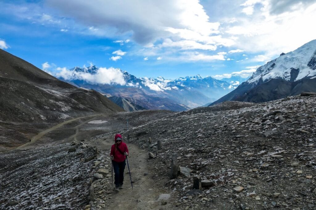 Tilicho Lake - A woman walking along a pathway towards the Tilicho Lake