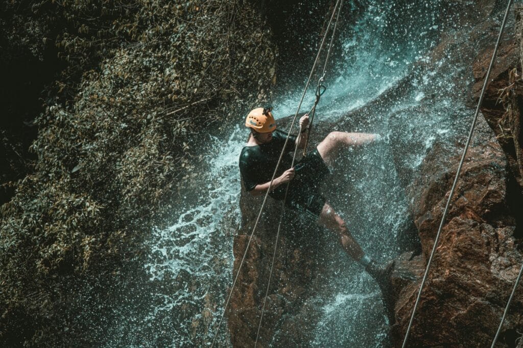 Men Canyoning in waterfall