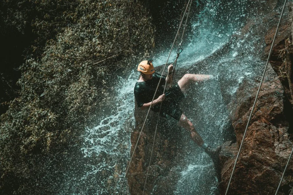 Men Canyoning in waterfall