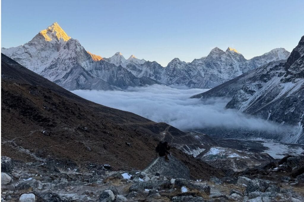 Trekker overlooking Mount Everest, Ama Dablam, and the Khumbu Valley during the Everest Base Camp Trek.